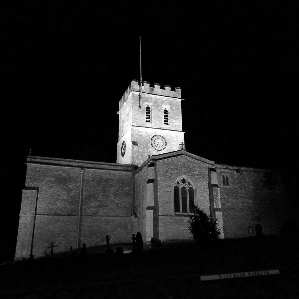 Exterior of St Nicholas' Church illuminated on a winter's night.
