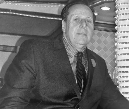 Don wearing a suit and tie.