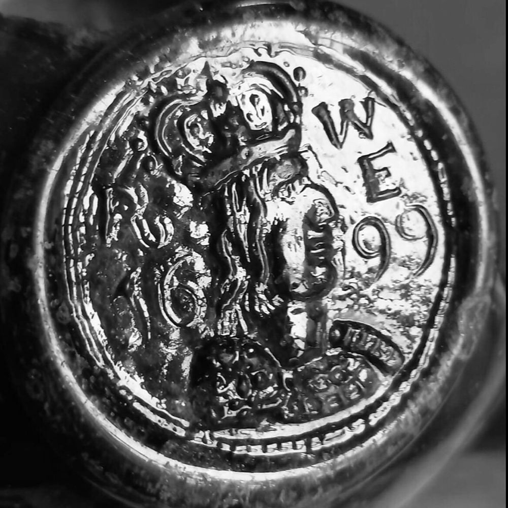 Bottom of an old glass bottle with the year embossed: 1699